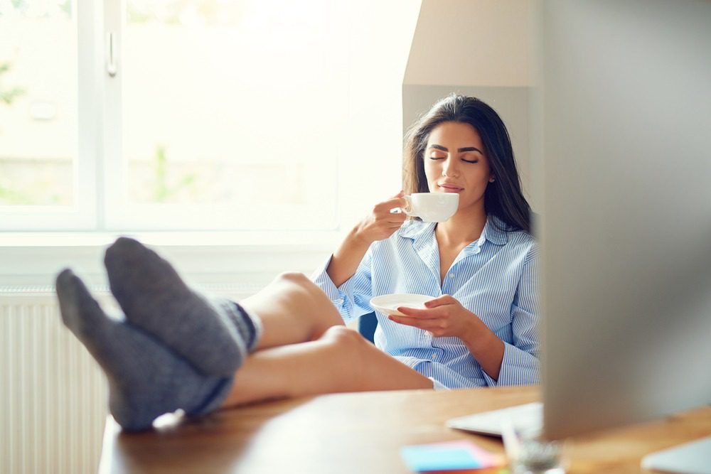 woman drinking coffee with elevated legs